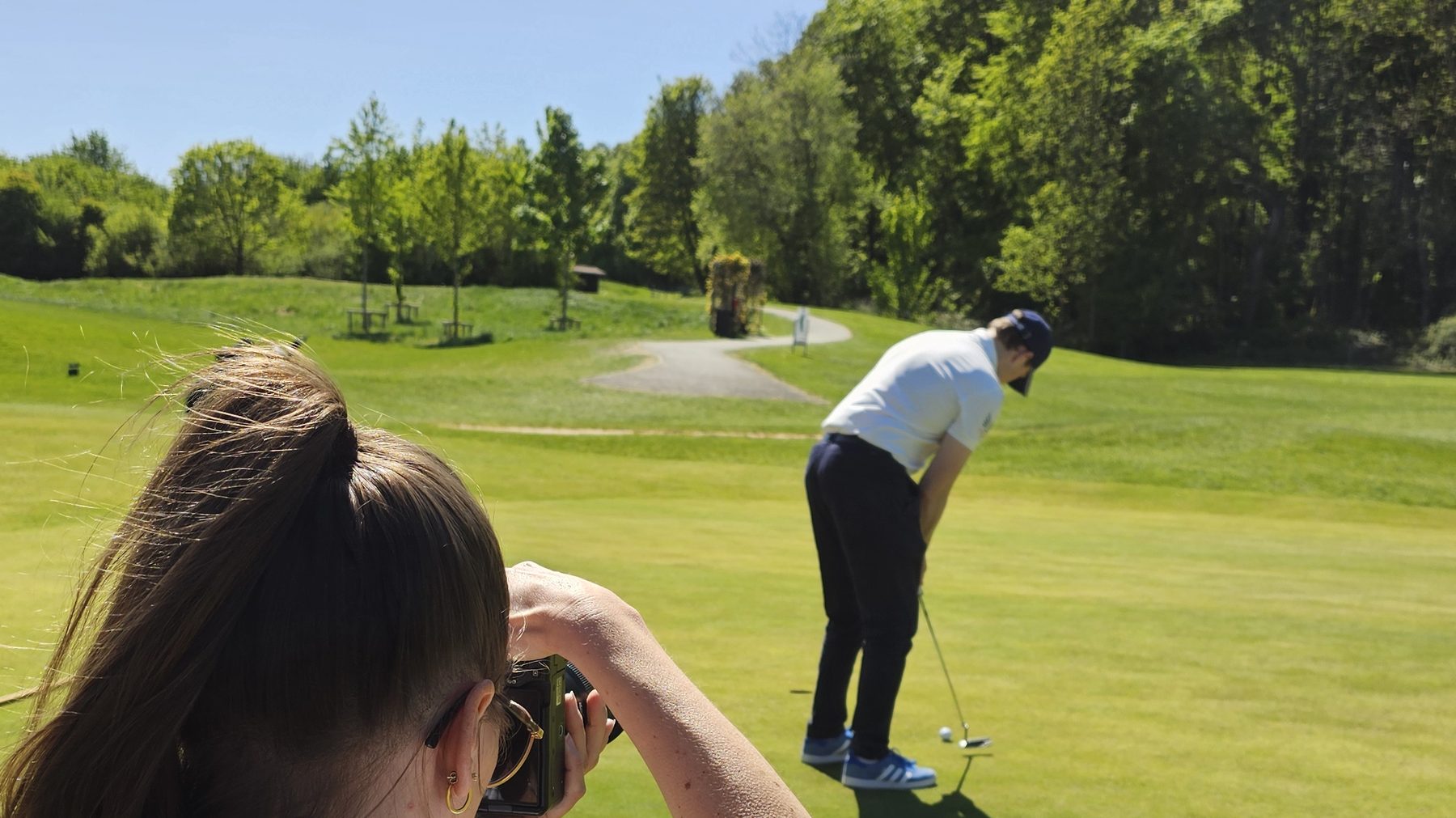 Alina fotografiert einen Golfer beim Putt