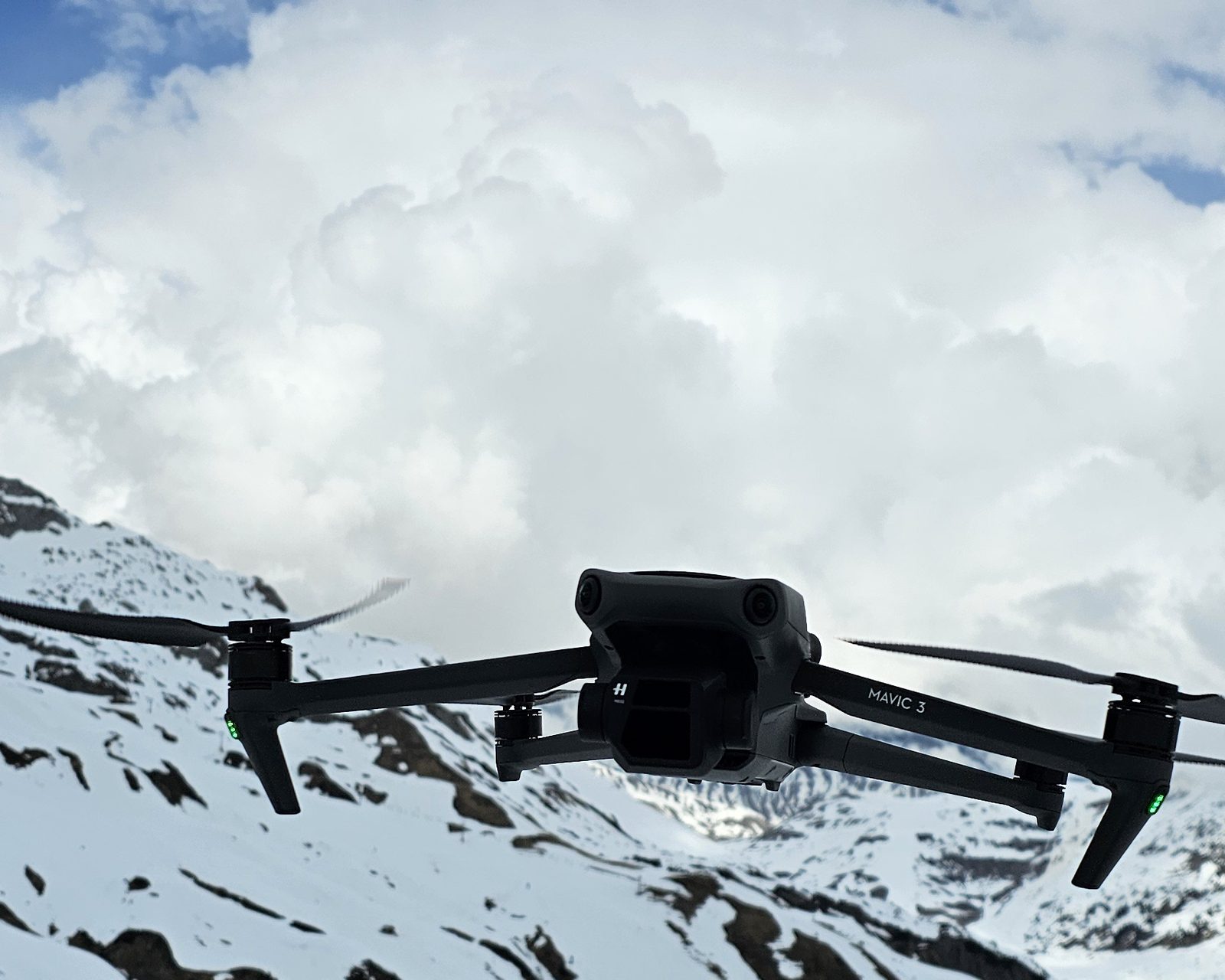 DJI Mavic 3 schwebt vor Wolkenkulisse in den Alpen