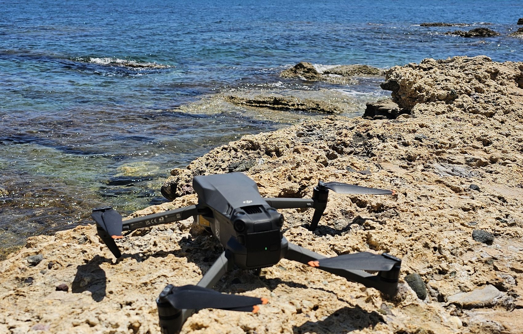 DJI Mavic 3 an der Felsenküste am türkisen Meer